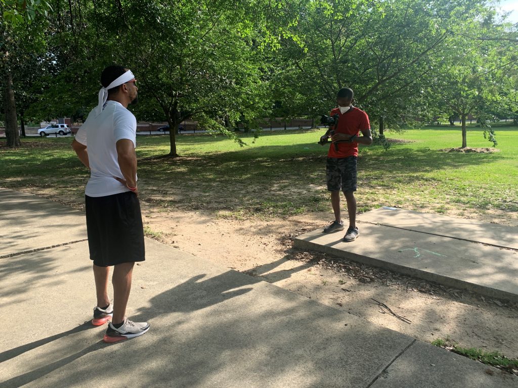 A man films another man in a park