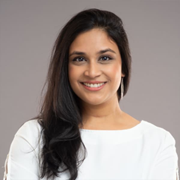 A headshot of a woman with black hair and a warm smile.