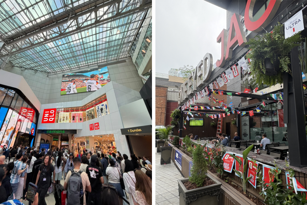 World Cup fans gather inside CF Toronto Eaton Centre beneath a large screen showing a football match, while a nearby outdoor restaurant patio is decorated with international flags and World Cup-themed banners.